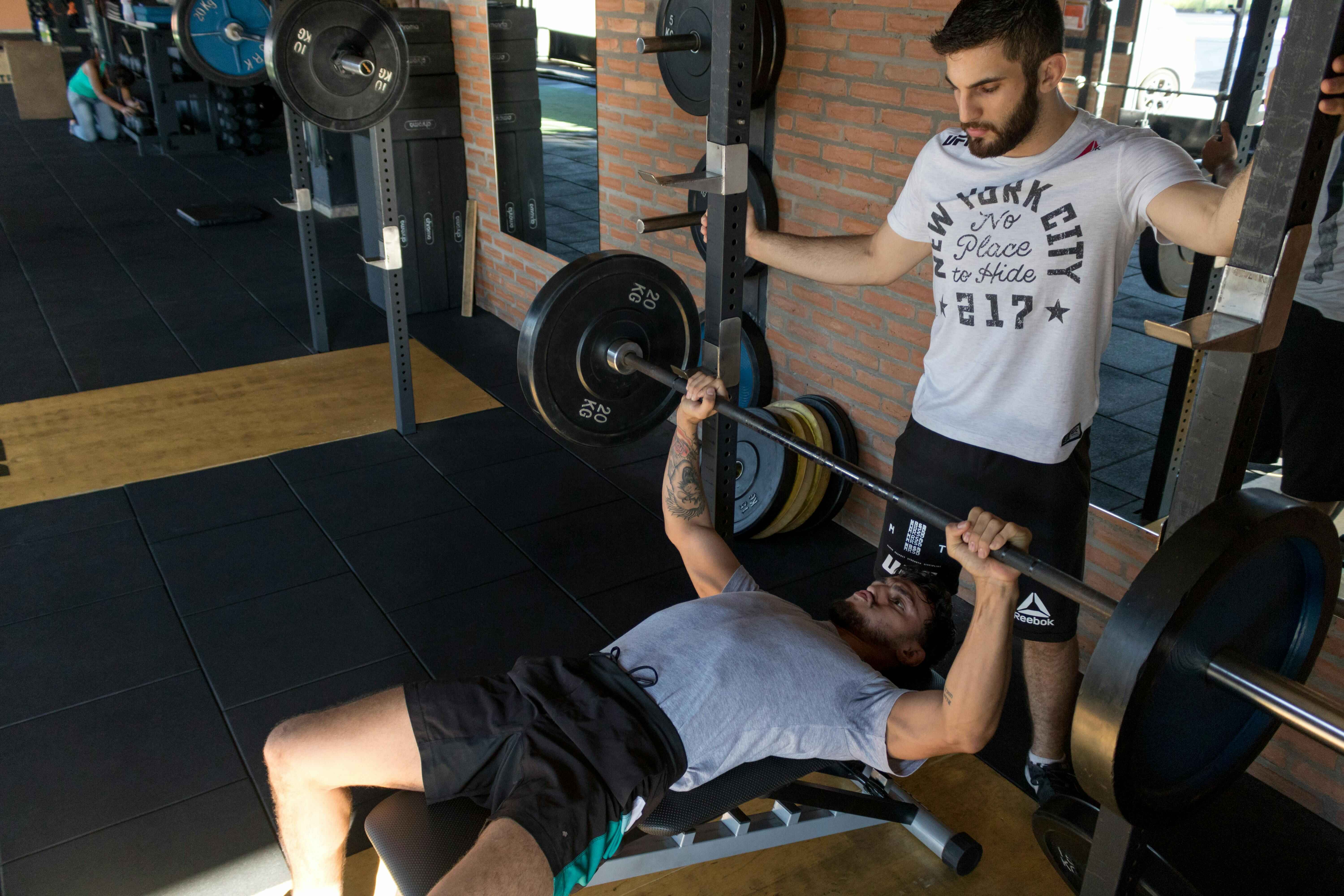 Personal trainer supporting strength training at FabbFitt